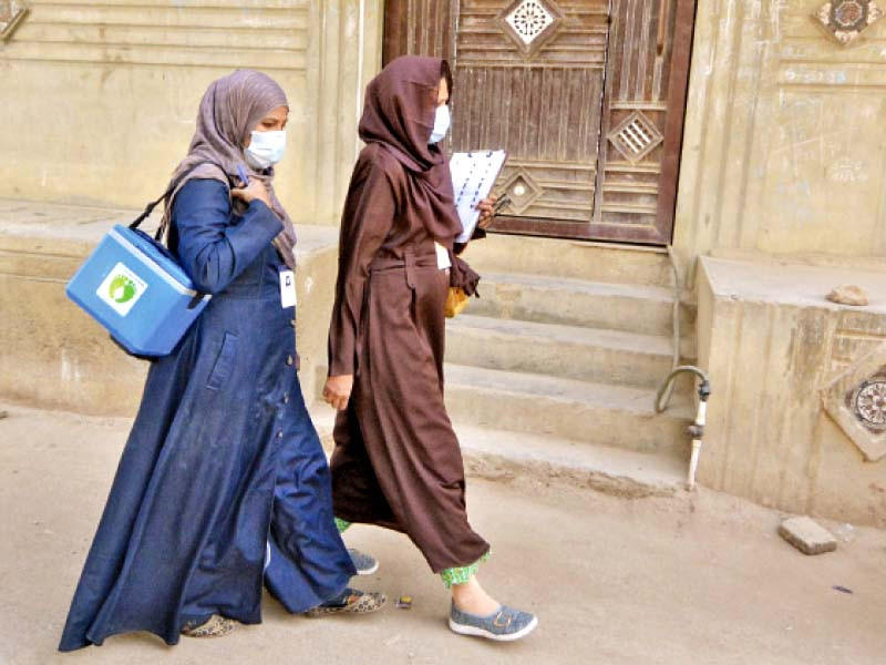 polio vaccinators carrying bag of vaccines and documents to collect data walk through a neighbourhood in karachi at the start of a nationwide inoculation drive photo jalal qureshi express