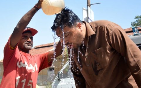 an edhi volunteer is offering water to a passer by providing relief from the scorching heat in front of the edhi centre in karachi s tower area on april 29 2024 photo express